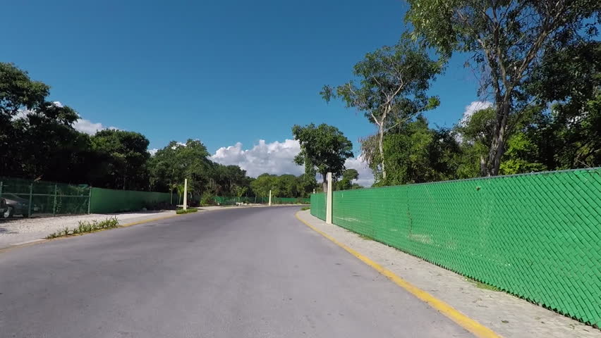 PLAYA DEL CARMEN, MEXICO -DEC 2016: Mexico drive POV rural roads Cancun area. Tourist destination for Luxury resorts along Mexican Mayan Riviera. Local business and residents along road.