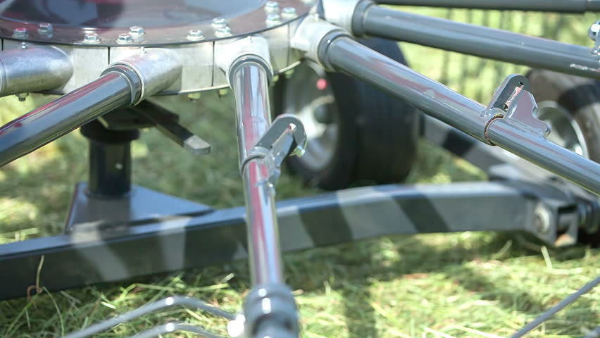 A young man is unwinding a button and he is taking one part out of the machinery. Then he is placing it somewhere else.