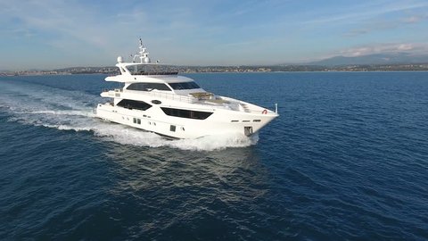 CANNES – OCTOBER 20: drone passes in front of a 110 feet long luxury yacht navigating on calm sea on October 20, 2016 in Cannes, France
