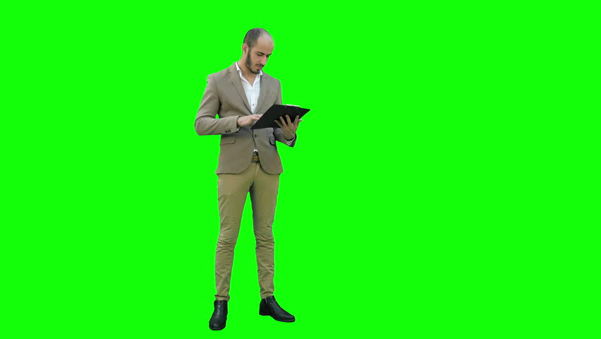 Concentrated businessman reading important report on a Green Screen, Chroma Key.
