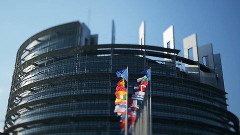 Impressive European Parliament building in Strasbourg, France with flags waving on a spring morning - real tilt-shift lens used to put the accents to the waving flags