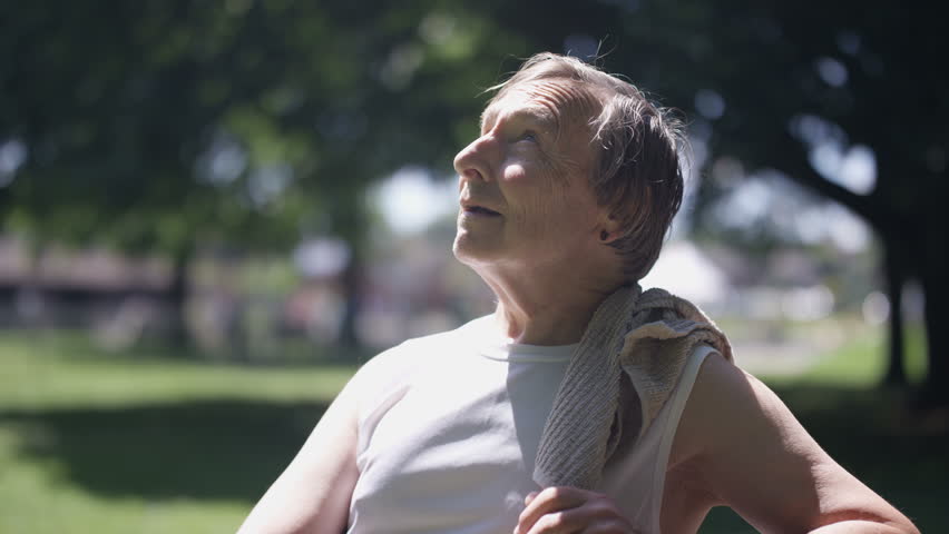4K Portrait healthy & active senior man taking a break from exercising in park Dec 2016-UK