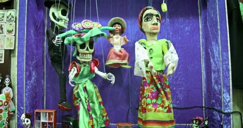 SAN DIEGO, USA - NOVEMBER 2016; Colorful mexican dancing puppets. Traditional folk art marionettes in national costumes. Day of the Dead celebration symbols.