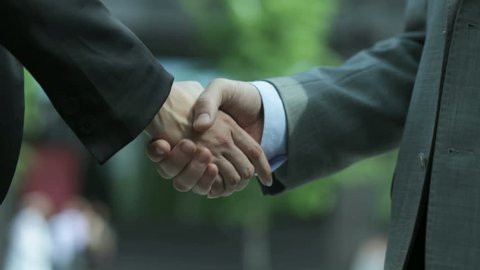 Close-up of two business people shaking hands to conclude the deal