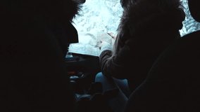 Friends traveling together by car in winter, looking for the right way on the map. 4K UHD, 60 FPS SLO MO, RAW edited footage