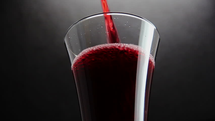 Cherry juice in glass on black background