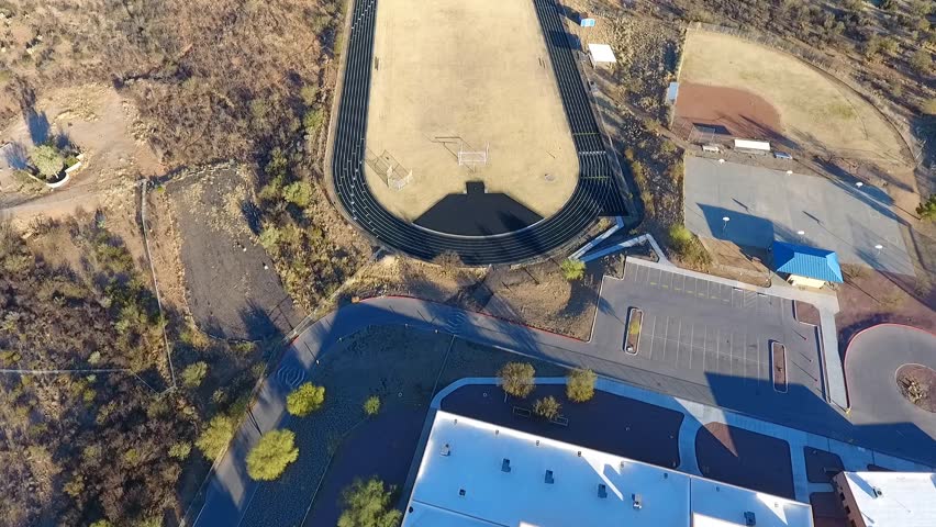 Aerial flyover of a running track and sports field