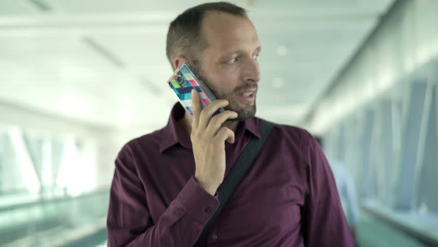 Young man talking on the cellphone on the escalator stairs