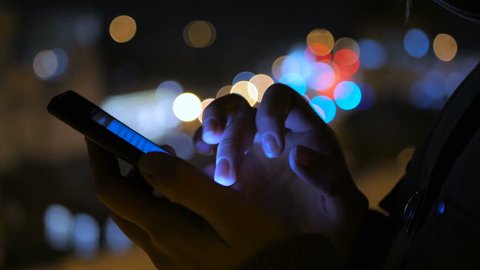 Close-up shot of woman hands with smartphone in the city at night. Technology, winter and holiday concept Video Stok