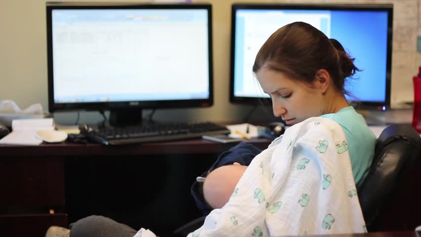 A mother breastfeeding her baby boy at work