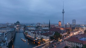 Panoramic view of Berlin at dusk. Cloudy sky. Day to night transition. City lights switch on. Timelapse video.