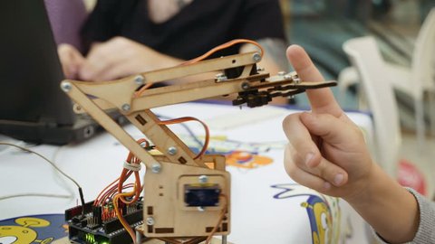 Small toy robot arm helps children to learn and understand robotics technology. Robots and automation are substitute for future human labor.