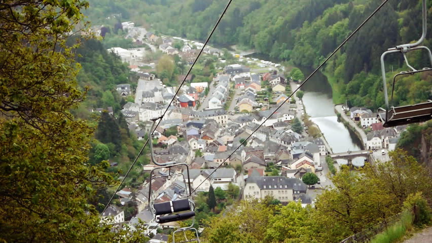 View of a valley in Luxembourg. The city of Vianden is in the distance. A chair