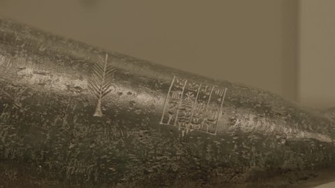 Manama, Bahrain - circa 2013 - CU tilt-down on a piece of black basalt carved with a feather and cuneiform writing from the Sumerian collection at the Bahrain National Museum.