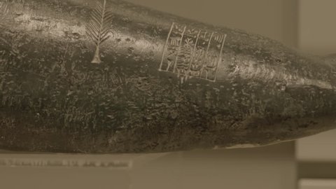 Manama, Bahrain - circa 2013 - CU tilt-up on a piece of black basalt carved with a feather and cuneiform writing from the Sumerian collection at the Bahrain National Museum.