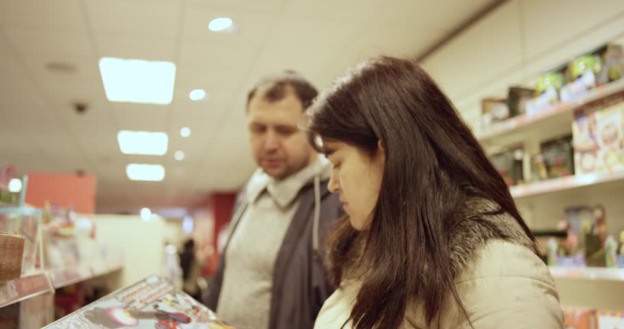 Mom and Dad read the instruction on a toy box. 4k