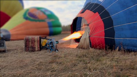 Propane gas burner filling balloon with hot air on the field Stock Video