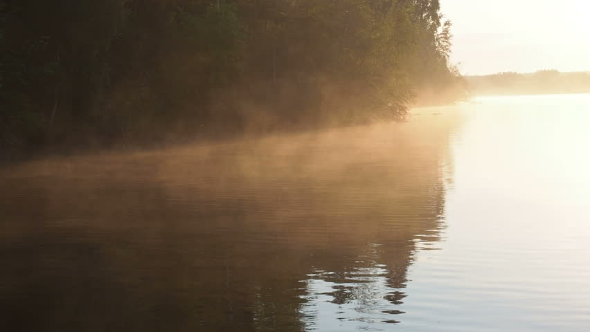 The golden light of the sun on the water surface of the lake. Golden sunset sunrise on the lake. Perspiration on the water in the sun light