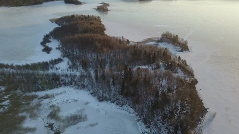 Aerial view: Ladoga Lake Skerries with bird's eye view on winter, January, Karelia, Russia. It is the largest lake in Europe, and the 15th largest freshwater lake by area in the world. 4K UHD