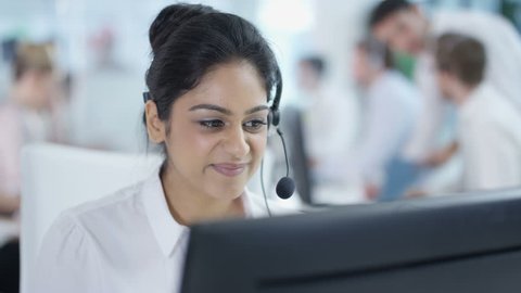 4K Friendly customer service adviser talking to a customer in busy call center Dec 2016-UK