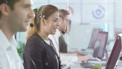 4K Portrait smiling customer service operator taking calls in busy call center Dec 2016-UK