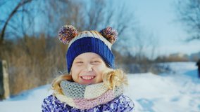 Girl 5 years enjoys a good winter day. Throws snow, laughing, positive emotions and funny faces