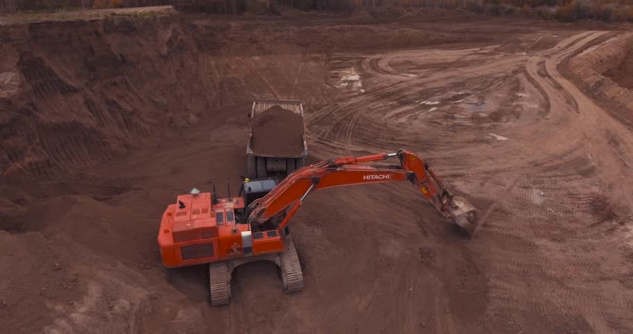 Drone over sand quarry with heavy machinery, the old truck and excavator.