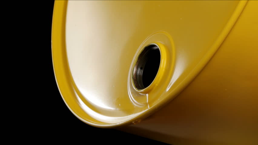 Oil drips out of yellow oil barrel