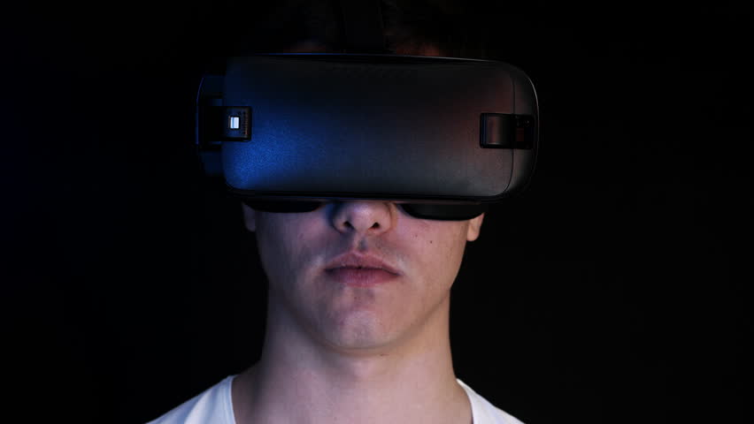 Close-up shot of a young man wearing VR Headset playing virtual reality games. Futuristic hud around him. Royalty-Free Stock Footage #22943266