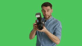 Mid Shot of a Handsome Photographer Taking Pictures with His Camera. Shot on Green Screen. Shot on RED Cinema Camera 4K (UHD).