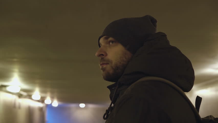 A young man goes in the underpass.