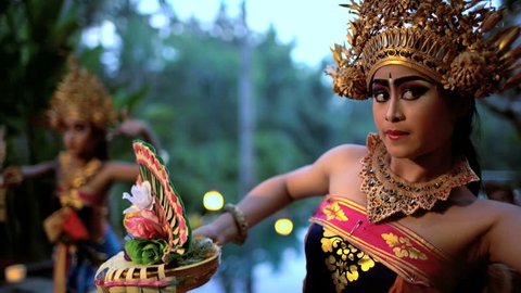 Balinese females performing artistic dance in ceremonial traditional colorful costume using hands and fingers Indonesia South East Asia