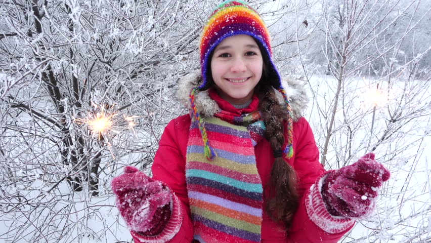 Happy girl in warm clothes with sparkles on winter forest landscape, slow motion 