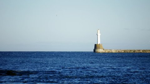 Lighthouse on sunny day in the North Sea Beach, Aberdeen, Scotland
