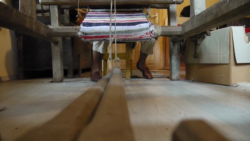 Legs of a woman working at the loom in the front room of the house 73b
