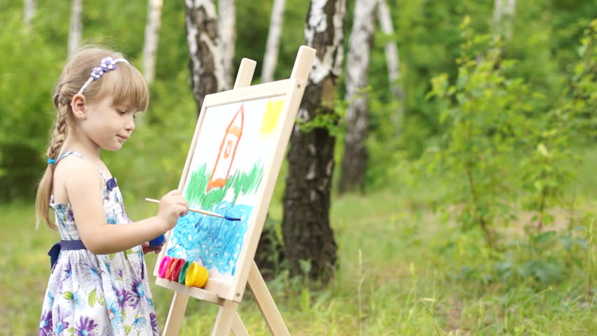 Child painter painting on easel