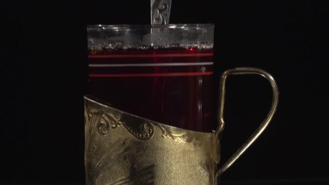black tea in the cup holder of gold in a dark room
