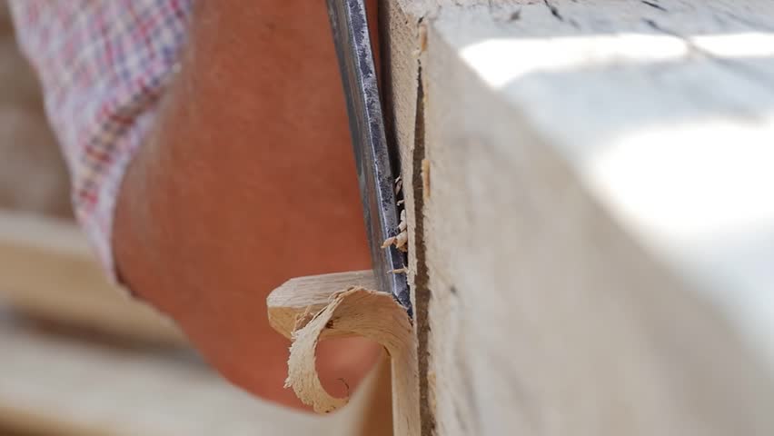 Detail in slow-motion with a worker who process wood with a chisel iron 71a
