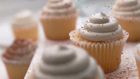 Cinnamon sprinkled onto vanilla cupcakes in super slow motion, shot on Phantom Flex 4K