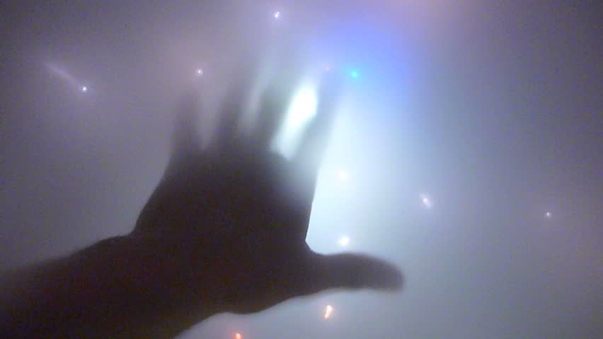 Abstract visual hand and overhead lights appearing to be an alien space craft.