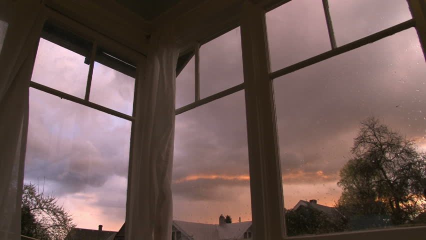 Full sunset time lapse through old windows in house. Rain clouds develop and