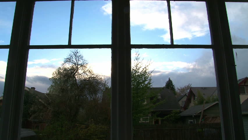 Full sunset time lapse through old windows in house with storm and rain clouds.