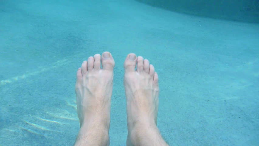 Man's feet point of view floating in large spa.