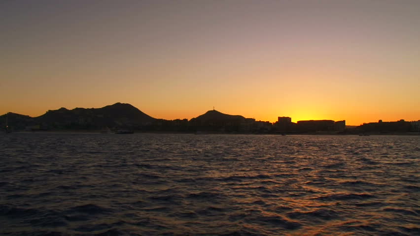 Sunset over Cabo San Lucas, Mexico and ocean water from boat.