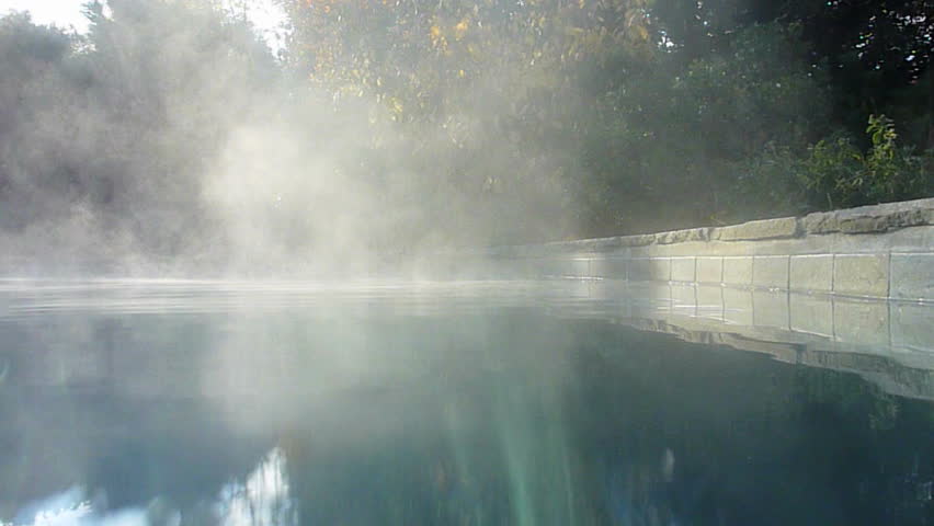 Warm outdoor spa on sunny day showing steam rising.