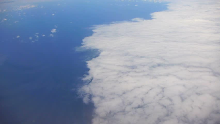Flying in airplane over ocean and large storm front over the Pacific.