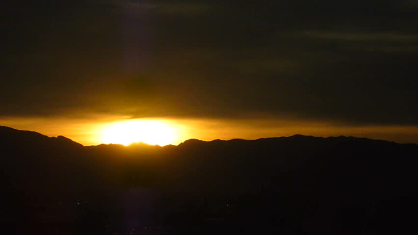 Sunset over mountain range, time lapse.