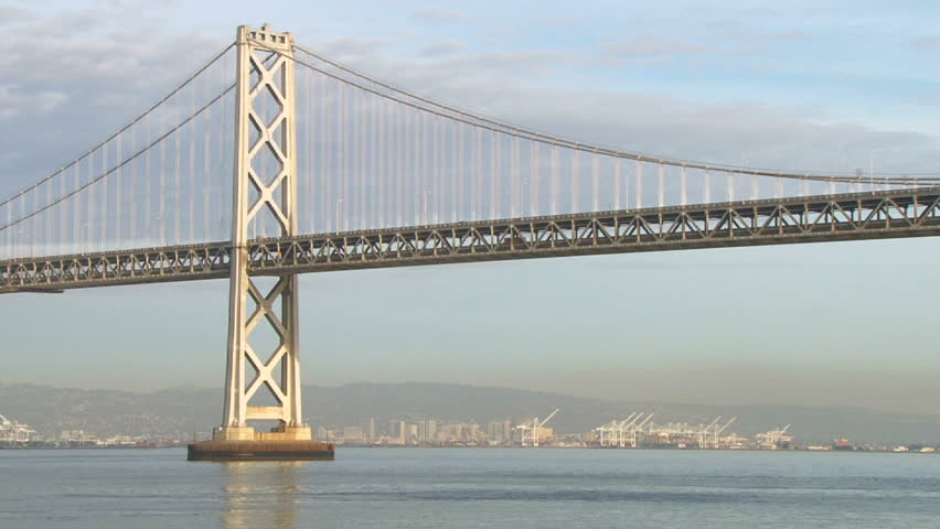 Long shot of the Oakland Bay Bridge in San Francisco, California on bright,