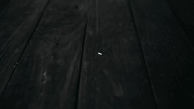 Rice grains falling on the wooden black table, slow motion