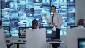 4K Security officer communicating with staff in observation control room Dec 2016-UK